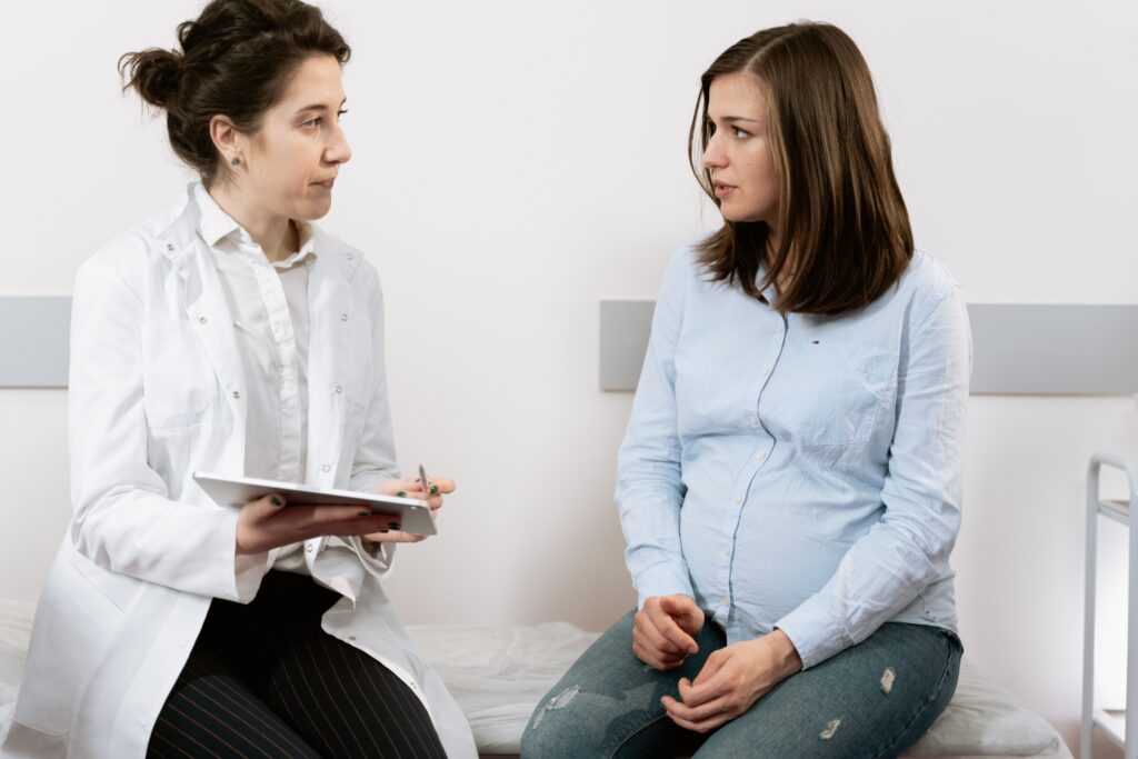 pexels-photo-7088531-7088531 Eine schwangere Frau, die sich mit einer Ärztin in einer medizinischen Klinik berät.