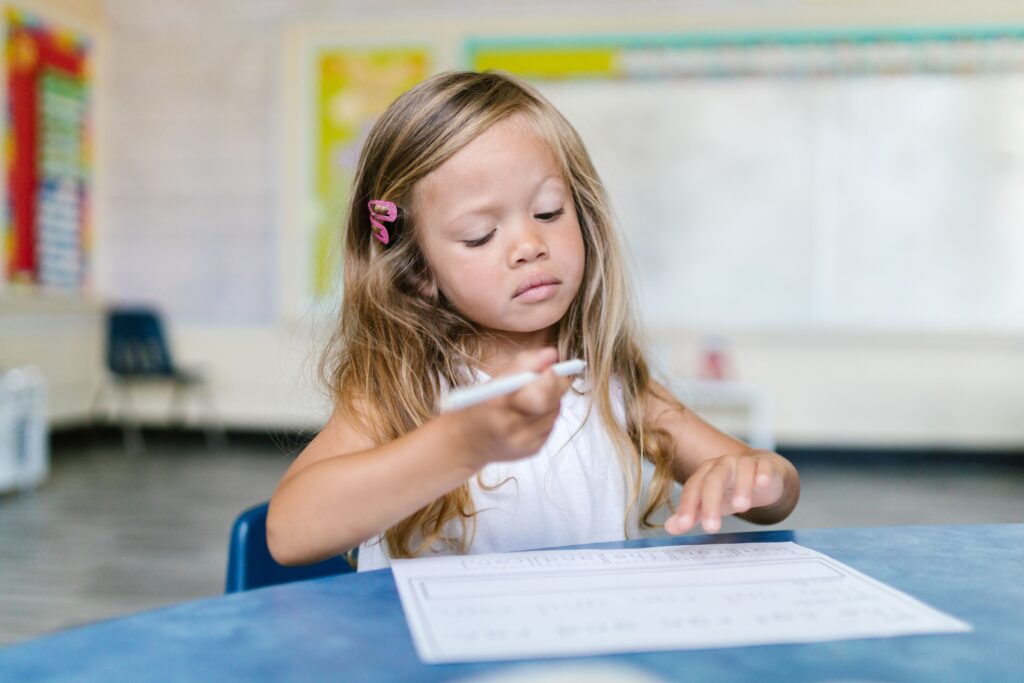 pexels-photo-8363759-8363759 Ein junges Mädchen schreibt aufmerksam in einem Klassenzimmer und fängt einen Moment des fokussierten Lernens ein.